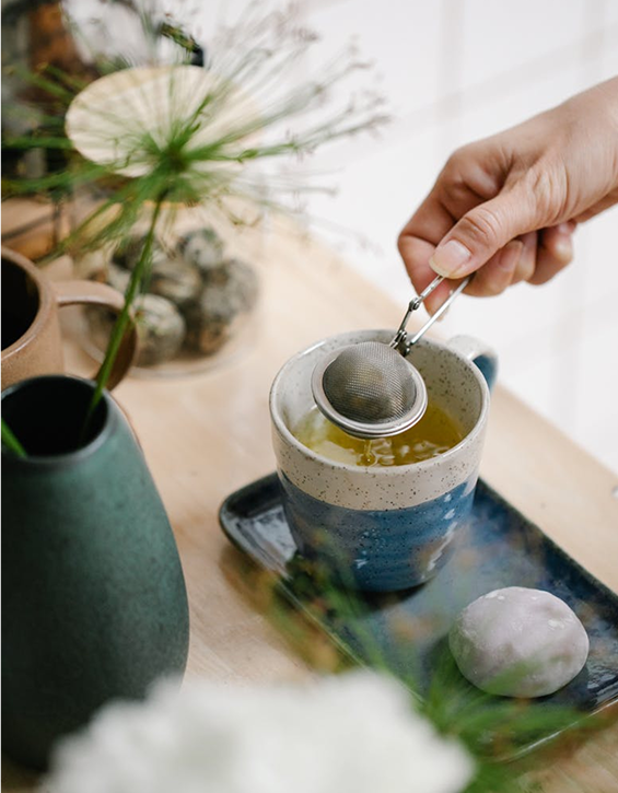 Tea brewing process with hand using tea strainer